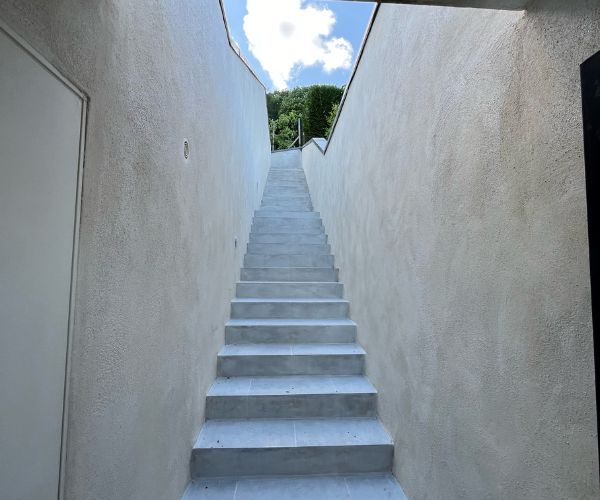 Escalier béton armé et enduit, vue depuis le bas, chantier à Rouen par un artisan maçon
