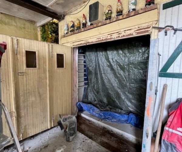 Mur en béton armé blanc avec briques de verre et porte d’entrée en acier noir posée en tunnel