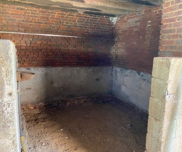 Nettoyage et préparation des murs en briques avant rénovation intérieure