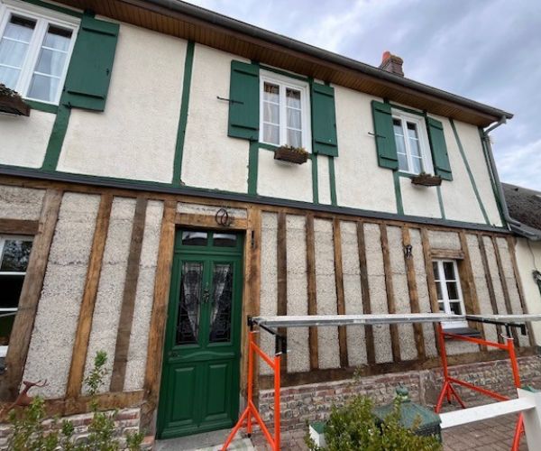 Façade en cours de rénovation avec enduit ton pierre entre colombages bois