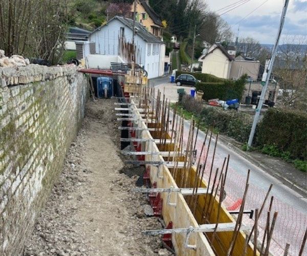 Coffrage d'un mur en béton armé sur un chantier de maçonnerie à Rouen.