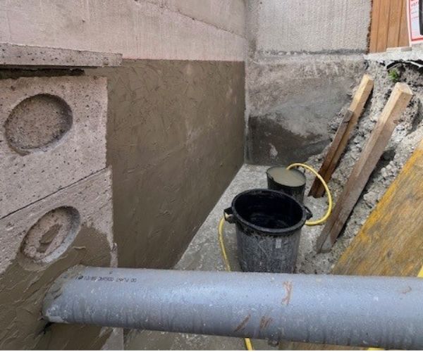 Application d'un enduit d'étanchéité sur un mur enterré à Rouen.